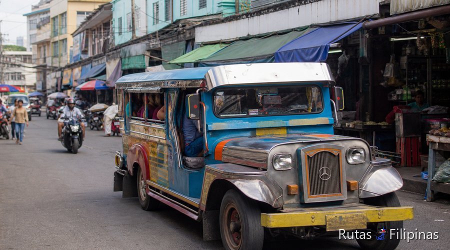 Jeepney de colores en una calle de Cebú city, con comercio local y calor de media mañana