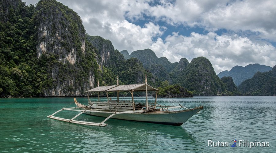Bangka blanca entre karsts de caliza y agua turquesa en Palawan